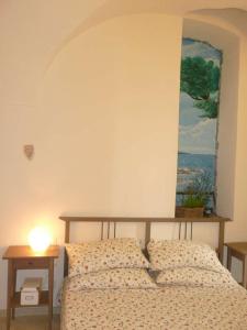 een slaapkamer met een bed en een tafel met een lamp bij Casa Della Lavanda in Santo Stefano al Mare