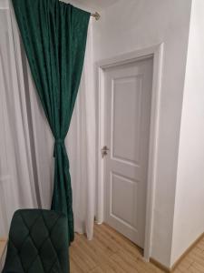 a door with a green curtain in a room at The Nest in Brăila