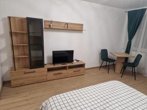 a bedroom with a television on a dresser with two chairs at The Nest in Brăila