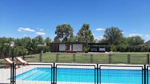 une piscine avec une maison en arrière-plan dans l'établissement Punto Alma Home box, à San Rafael