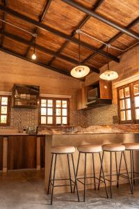 una cocina con techos de madera y taburetes de bar en Privada y comoda cabaña, Casa Margarita, Villavieja, en Villavieja