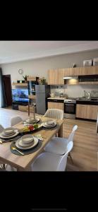 a kitchen with a wooden table and white chairs at Apart-Hotel Crown Bansko in Bansko