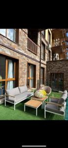 a patio with couches and a coffee table in front of a building at Apart-Hotel Crown Bansko in Bansko