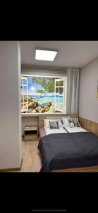 a bedroom with two beds and a large window at Apart-Hotel Crown Bansko in Bansko +8 photos