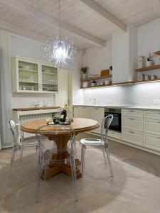 una cucina con tavolo, sedie e lampadario pendente di A Luxury 100m2 Apartment in a Chic Vineyard Villa - Ca' S. Lorenz a Dobrovo