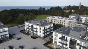 una vista aérea de una ciudad con edificios y el océano en Apartament el sol, en Gąski