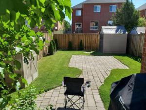 a chair sitting in the middle of a yard at Centrally Located Stylish House in Vaughan