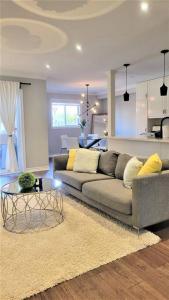 a living room with a couch and a table at Centrally Located Stylish House in Vaughan