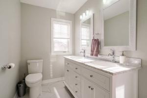 een witte badkamer met een wastafel en een toilet bij Centrally Located Stylish House in Vaughan