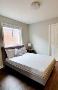 een slaapkamer met een groot bed en een raam bij Centrally Located Stylish House in Vaughan