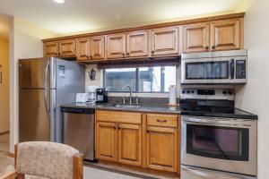 uma cozinha com armários de madeira e electrodomésticos de aço inoxidável em Seven Springs Stoneridge 3 Bedroom Standard Condo, Private Deck condo em Champion