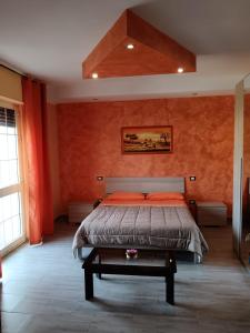 SupersanoにあるLu Sule B&Bのベッドルーム1室(オレンジ色の壁のベッド1台付)