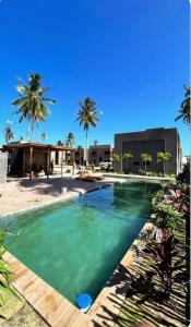 een zwembad met turquoise water en palmbomen bij Villas Patacho - A001 - Rota ecológica Milagres in Pôrto de Pedras