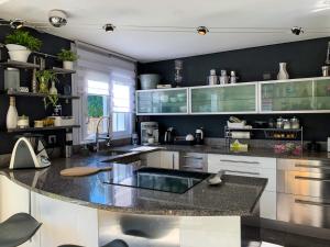 une cuisine aux murs noirs et un grand îlot de cuisine dans l'établissement Maison familiale à caumont sur durance, à Caumont-sur-Durance