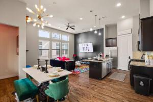 eine Küche und ein Wohnzimmer mit einem Tisch und Stühlen in der Unterkunft Prolific Theme Suite Ft Jacuzzi Tub 9Os Fun & Content Spaces in Houston