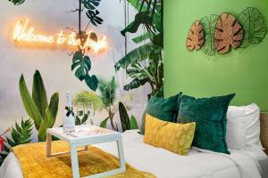 ein Zimmer mit einem Sofa mit einem Tisch und Pflanzen in der Unterkunft Prolific Theme Suite Ft Jacuzzi Tub 9Os Fun & Content Spaces in Houston