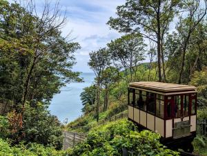 a trolley driving down a hill with a view of the ocean at Sandown - 2 minutes walk to the Downs, Restaurants Bars & Beaches in Torquay