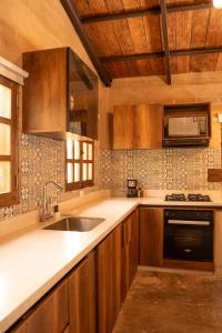 a kitchen with wooden cabinets and a sink at Privada y comoda cabaña, Casa Margarita, Villavieja in Villavieja