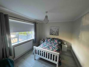 a small bedroom with a bed and a window at Cosy 4 bed bungalow in quiet residential area! in Strabane