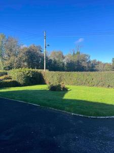 a field of green grass next to a street at Cosy 4 bed bungalow in quiet residential area! in Strabane