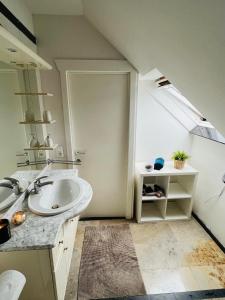 a white bathroom with a sink and a window at Isa's Appartement in Lommel