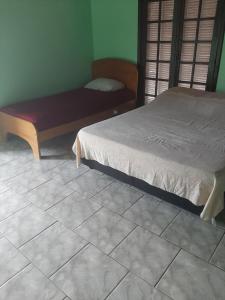 um quarto com uma cama e um banco num piso de azulejo em Kitnet em Matinhos PR Balneário Riviera em Matinhos