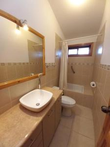 a bathroom with a sink and a toilet and a mirror at La Loma in Cajamarca