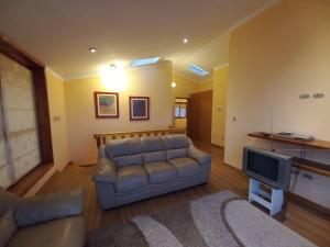 a living room with a couch and a television at La Loma in Cajamarca