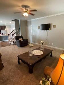 a living room with a table and a ceiling fan at Spacious Home Near Shaw in Sumter