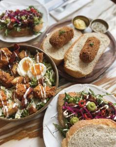 a table topped with plates of food and bread at Boutique Hotel Huys Oud Teylingen in Warmond