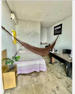 a room with a bed and a hammock in it at Seu lar Fora de Casa! in Juazeiro do Norte
