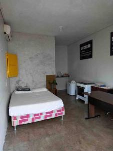 ein Schlafzimmer mit einem Bett, einem Schreibtisch und einem Klavier in der Unterkunft Seu lar Fora de Casa! in Juazeiro do Norte