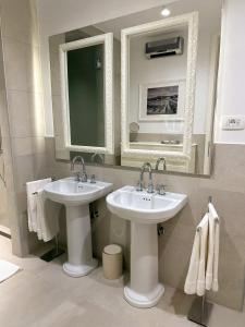 y baño con 2 lavabos, espejo y toallas. en A Luxury 100m2 Apartment in a Chic Vineyard Villa - Ca' S. Lorenz, en Dobrovo