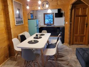 eine Küche und ein Esszimmer mit einem Tisch und Stühlen in der Unterkunft Dom Nad Stawem Dłużec 55A in Mrągowo