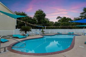 einen Pool mit blauen Stühlen und Sonnenschirmen in der Unterkunft Luxury Beach Retreat Townhouse Sleeps 8 in Gulfport