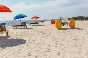 einen Strand mit Bänken und Sonnenschirmen auf dem Sand in der Unterkunft Luxury Beach Retreat Townhouse Sleeps 8 in Gulfport