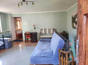 a living room with a blue couch and a chair at Casa di Viu' in Viù