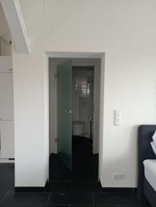um corredor para uma casa de banho com WC num quarto em Ferienwohnungen Fabry 2 2 em Saarbrücken