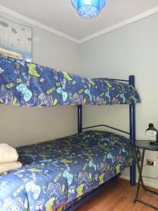 a bedroom with a bunk bed with a blue blanket at Departamento en Reñaca in Viña del Mar