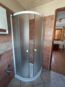 una ducha con puerta de cristal en una habitación en Casa di Viu', en Viù