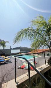 Blick auf einen Pool mit einer Palme in der Unterkunft Casinha do Orjal in Ponte de Lima