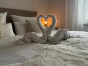 dois cisnes a fazer um coração numa cama em Strandzone 29 em Kronsgaard