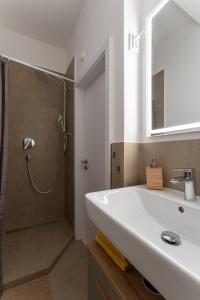 a white bathroom with a shower and a sink at 3-Zimmer-Apartment in einer ruhigen Seitenstraße im Nürnberg Nord in Nuremberg