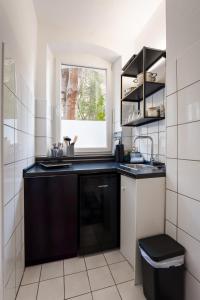a kitchen with a black sink and a window at 3-Zimmer-Apartment in einer ruhigen Seitenstraße im Nürnberg Nord in Nuremberg