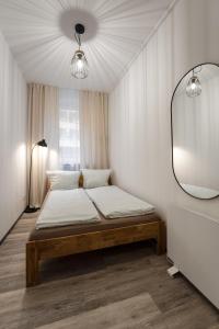 a bedroom with a bed with a mirror on the wall at 3-Zimmer-Apartment in einer ruhigen Seitenstraße im Nürnberg Nord in Nuremberg