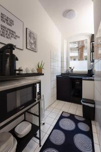 eine kleine Küche mit einer Spüle und einer Theke in der Unterkunft 3-Zimmer-Apartment in einer ruhigen Seitenstraße im Nürnberg Nord in Nürnberg
