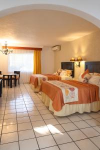 科利馬的住宿－瑪麗亞伊莎貝爾酒店，酒店客房设有两张床和一张桌子。