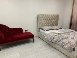 a bedroom with a bed and a red couch at 2 Bedroom Property Independent with Pakring in High Wycombe