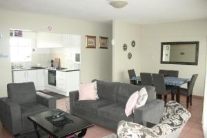a living room with a couch and a kitchen at Libem Lodge 11 in Edenvale