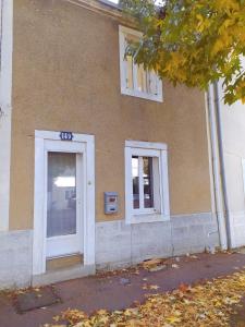un edificio con una puerta blanca y dos ventanas en C'COZY - grande maison calme et lumineuse en Sablé-sur-Sarthe